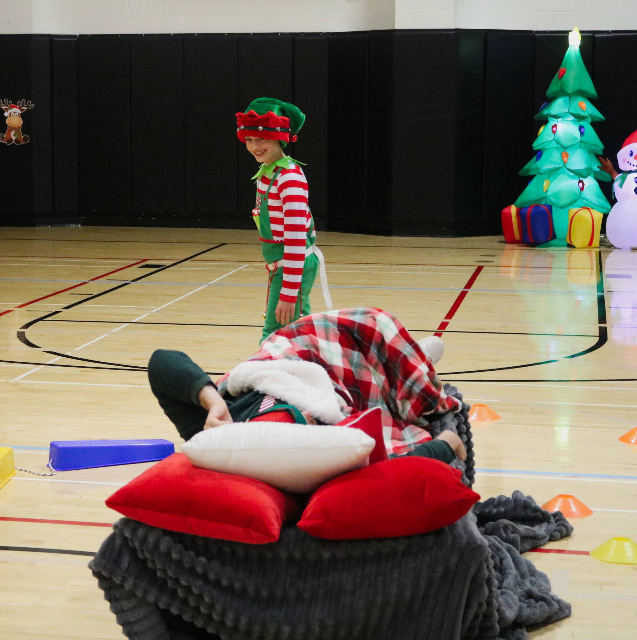 Photo by Bailey Jo Josie/Sound Publishing.
One of the cadets from the annual Elf Academy tries to sneak around the sleeping head elf without waking him up. Cadets have to go through an obstacle course with bells on their belt without being too loud. The Elf Academy took place Saturday, Dec. 14. Photo by Bailey Jo Josie/Sound Publishing.