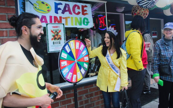 Mrs. Renton Ambassador Jennifer Brothers spins the wheel outside Smoking Monkey Pizza. Photo by Bailey Jo Josie/Sound Publishing